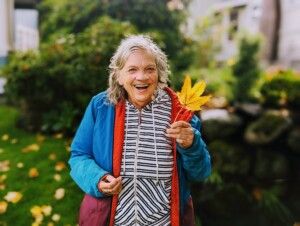 Core Member smiling with a large yellow leaf